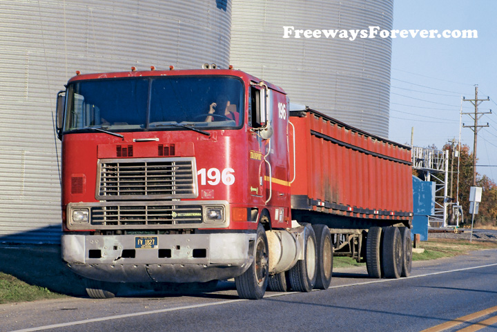 An International COE cabover truck in farm service waits in line on the shoulder of Fairgrounds Road at the Mountainaire Farms elevator in Harrington, Delaware