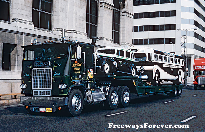 Silk Road Transport Freightliner cabover pulling a flatbed trailer with vintage Peter Pan limousine and bus